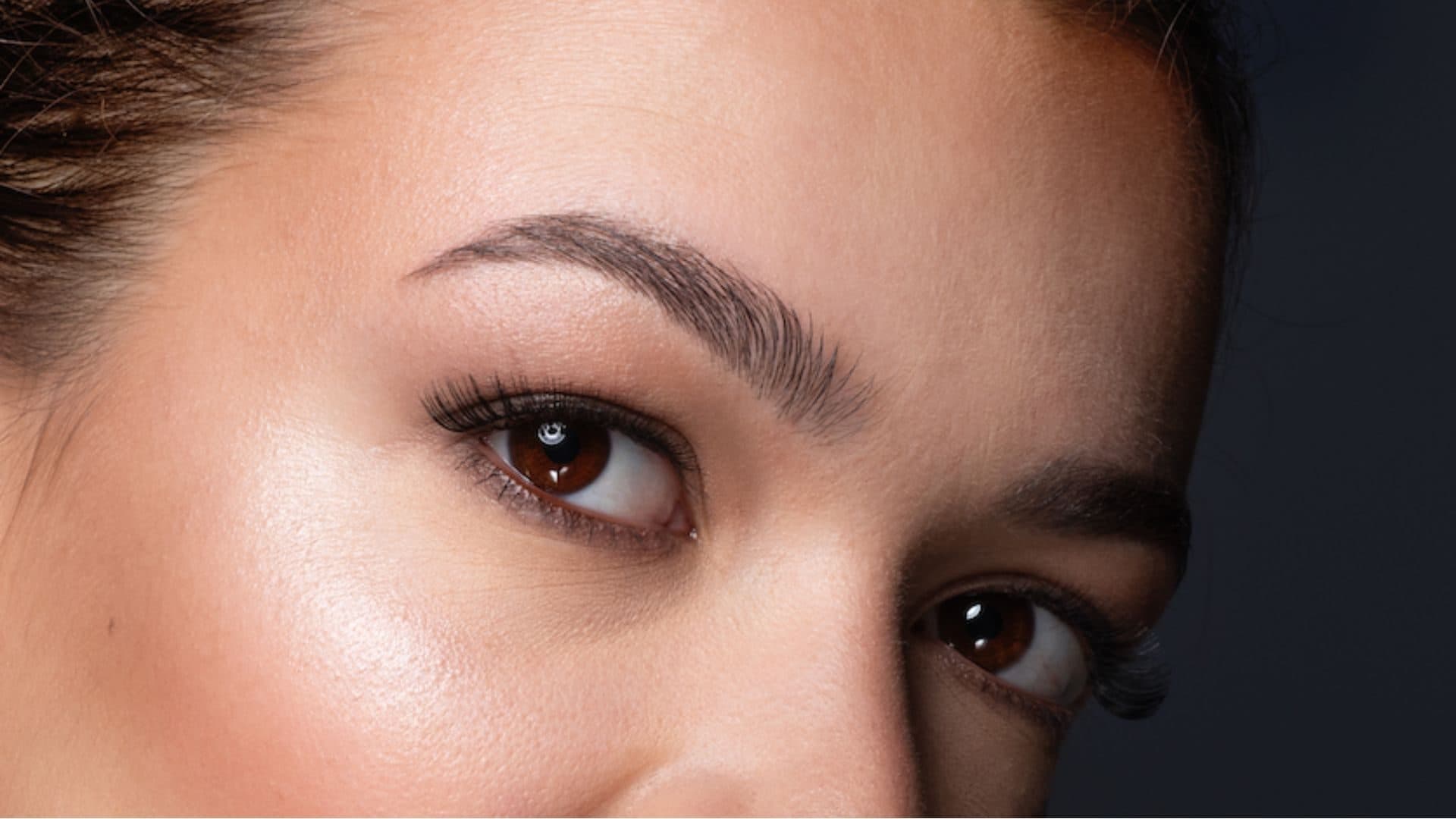 Regard d’une cliente aux sourcils dessinés et à la peau lumineuse